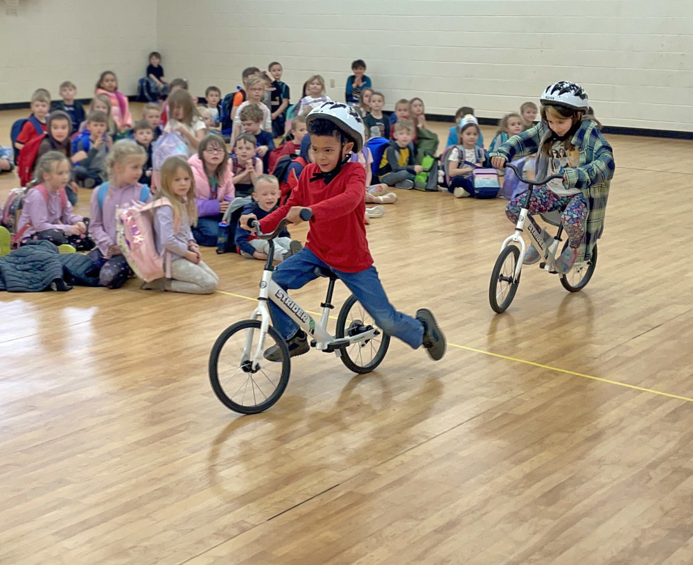 two kindergarten students ride bikes