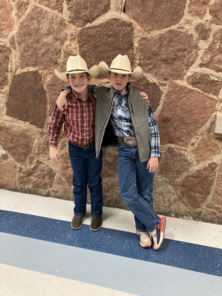 Two boys dressed in western wear.