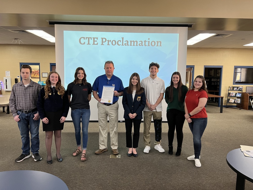 Seven high school students standing with town mayor