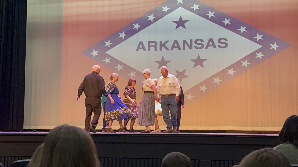 adults square dancing on stage