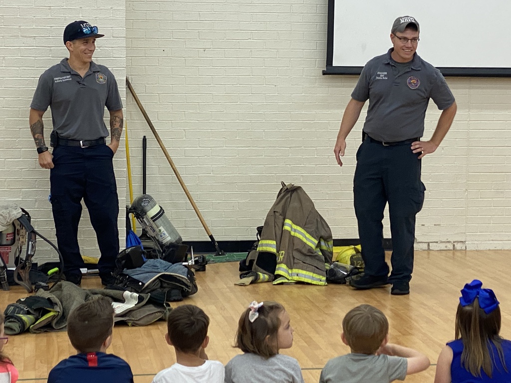 two firemen with kinder students