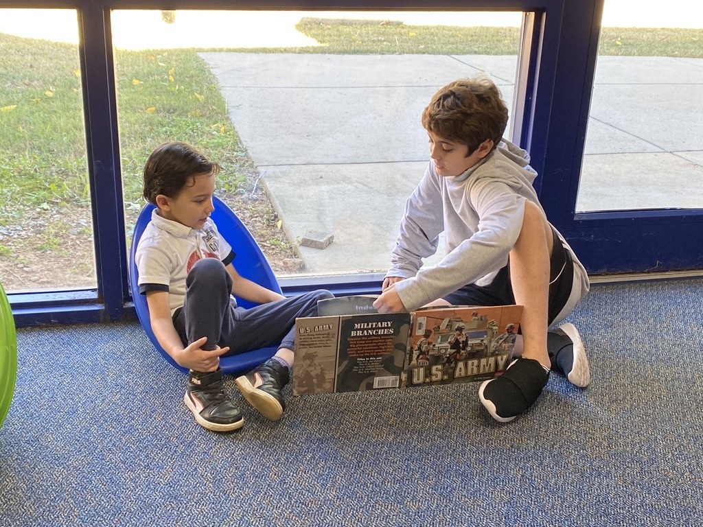older boy reading to younger boy