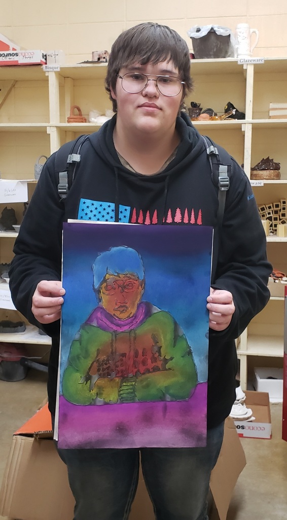 a high school boy holding her art project
