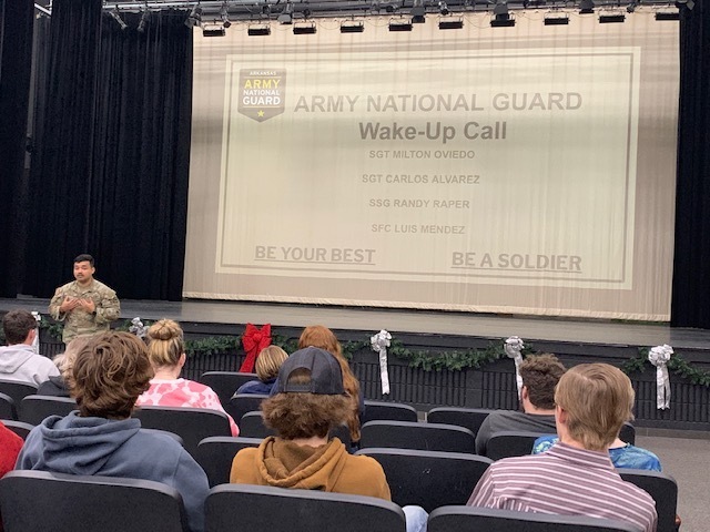 high school students watching a presentation from a national guard soldier in class