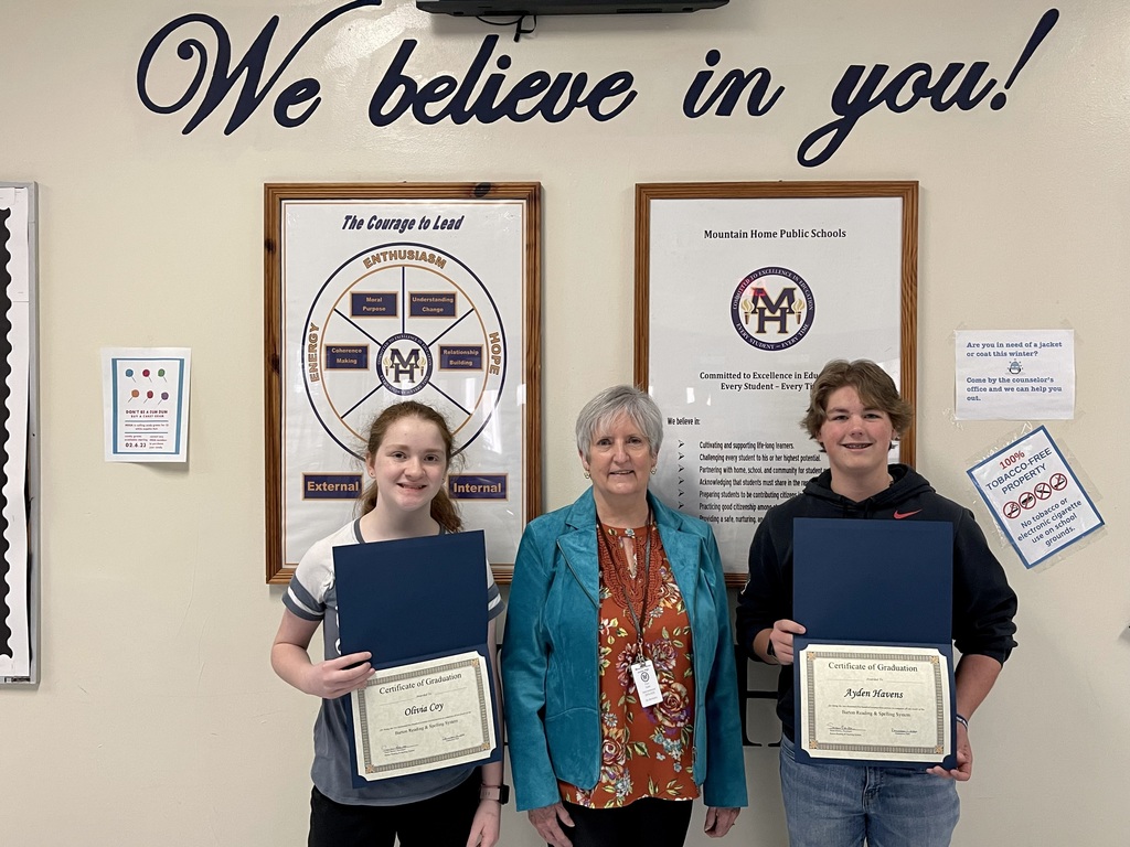 two junior high students pose with a teacher and two certificates
