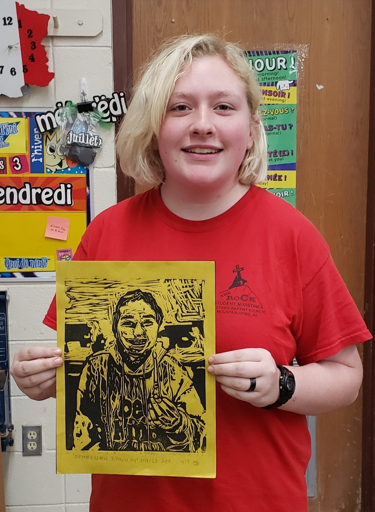 a teen girl holding an art project